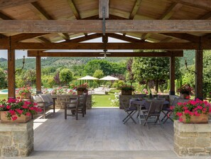 An outdoor patio with stone flooring, wooden furniture, and potted flowers. - Wonderful private villa for 7 people with WIFI, private pool, TV, patio and pets allowed (Castiglion Fiorentino)