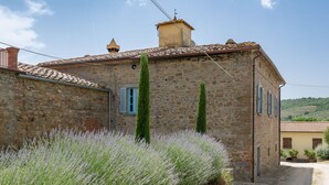 A stone building with a tiled roof, two tall trees, and a gravel path. - Beautiful private villa for 7 guests with private pool, WIFI, TV, patio and pets allowed (Castiglion Fiorentino)