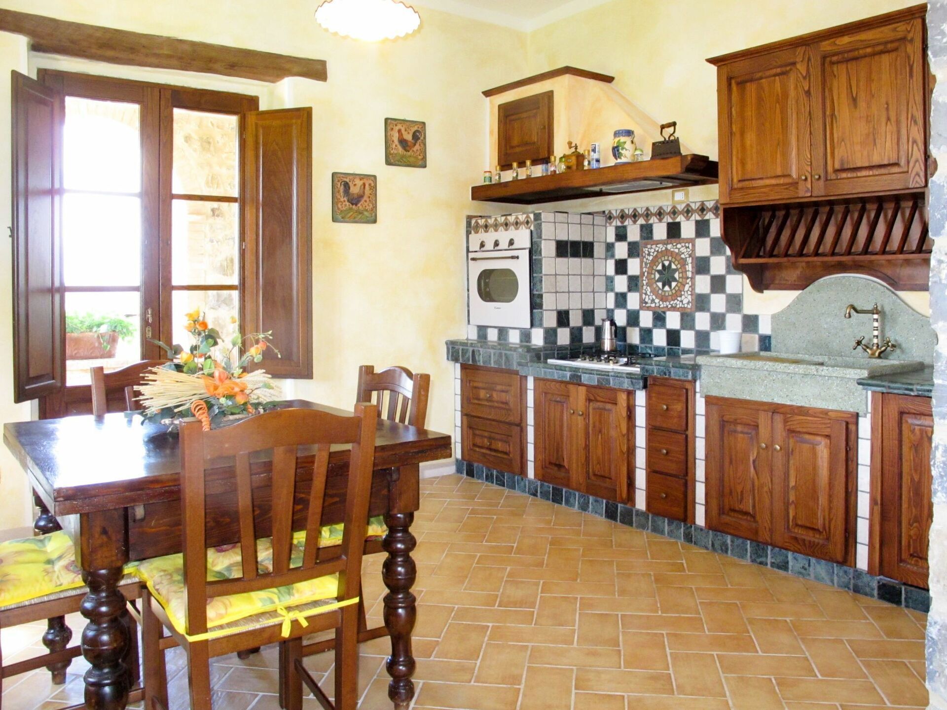 A kitchen with wooden cabinets, a tiled backsplash, and a dining area with a table and chairs.