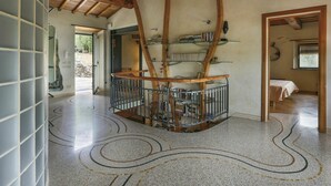 A spacious room with a high ceiling, exposed wooden beams, a spiral staircase, and a library with bookshelves. - Beautiful private villa for 9 guests with WIFI, A/C, private pool, TV, terrace and pets allowed (Buti)