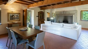 A spacious living area with a wooden ceiling, a fireplace, a white sofa, and a dining table with chairs. - Stunning private villa for 10 guests with WIFI, private pool, TV, patio and pets allowed (Londa)