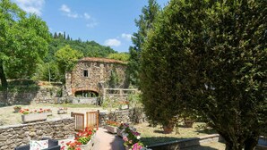 A stone building with a tiled roof, surrounded by a garden with flower beds and a paved pathway. - Stunning private villa for 10 guests with WIFI, private pool, TV, patio and pets allowed (Londa)
