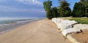 Ein Strand mit einer Steinmauer und Bäumen.