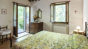 A bedroom with a bed, dresser, and two windows. - Stunning private villa for 4 guests with private pool, TV, patio and pets allowed (Camucia-monsigliolo)