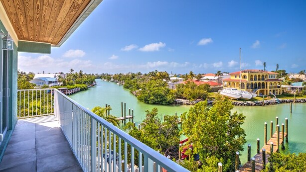 A balcony with a view of a river, boats, and buildings. - Walk to Sombrero Beach! (Marathon)