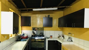 Una cocina compacta con estufa a gas, horno empotrado y pileta.