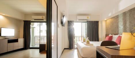 Una habitación de hotel moderna con cama, escritorio y televisor.