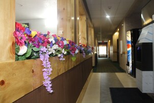 Un pasillo con mostradores de recepción de madera decorados con flores de colores.