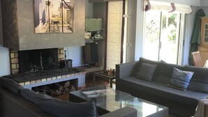 Ein Wohnzimmer mit Kamin, einer Couch, einem Couchtisch und einem Fernseher.