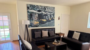 A living room with black sofas, a coffee table, and a painting on the wall. - NICE HOUSE ONLY 5 STREETS FROM THE CITY CENTER (Col Centro Cuatilulco)