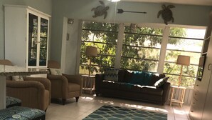 A living room with a sofa, armchairs, a coffee table, and a patterned rug. - Best Value on Manasota Key and Steps to Lemon Bay (Englewood)