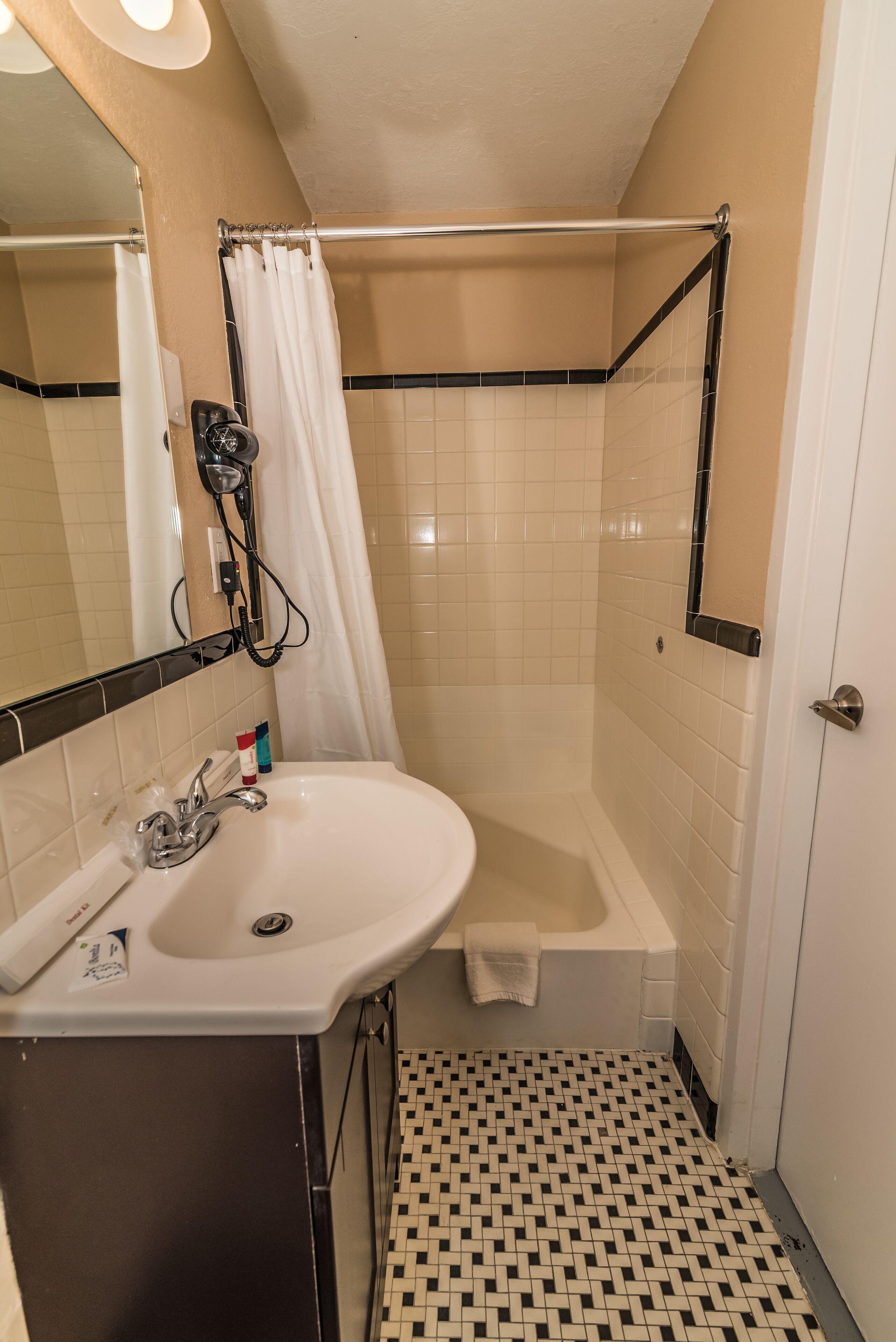 A bathroom with a white sink, a bathtub, and a shower curtain.
