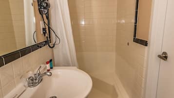 A bathroom with a white sink, a bathtub, and a shower curtain.