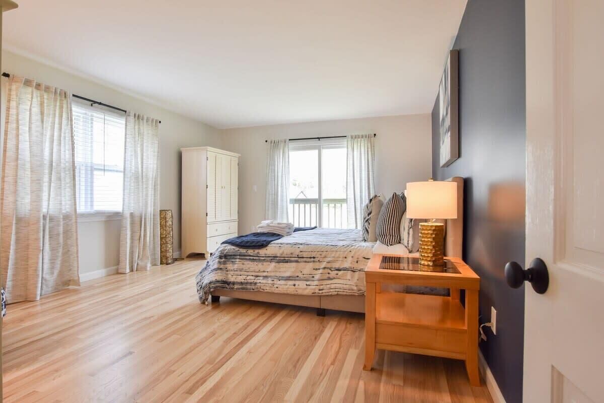 Een slaapkamer met een bed, een nachtkastje van hout en een kledingkast.