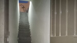 Eine schmale Treppe führt zu einem Raum mit blauen und beigen Wänden.