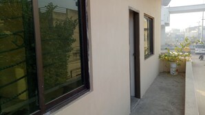 Ein Balkon mit Blumentopf, Fenster und Blick auf die Straße.