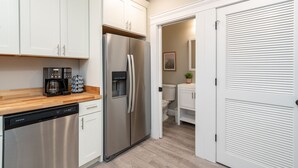 A modern kitchen with stainless steel appliances, white cabinetry, and a wooden countertop. - Historic 3BR Near Barnes Jewish Hospital | Walkable CWE | Dog-Friendly (St Louis)