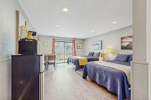 Two beds, a desk, and a window with curtains make this room a comfortable retreat.