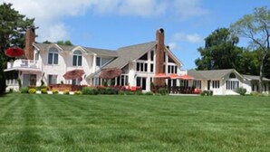 A large, two-story house with a well-maintained lawn and a patio area.