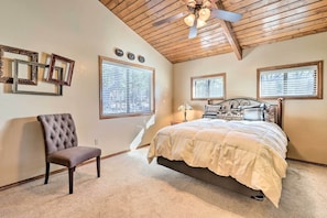 Cozy retreat with a high ceiling, exposed beams, and a comfortable bed.
