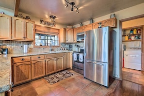 Enjoy cooking in this well-equipped kitchen with a large island, refrigerator, oven, and microwave.