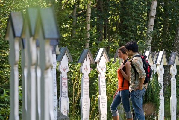 A wooden fence with signs, likely indicating a trail or boundary in a wooded area.