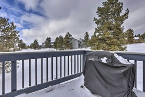 Enjoy al fresco dining on the covered grill, surrounded by snow-covered evergreen trees.