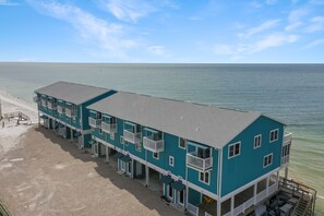 A multi-story hotel with balconies, located near a beach. - Beachfront, Corner Unit, North Cape San Blas - Pelican Crossing (Cape San Blas)
