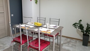 A dining area with a table set for four, including a fruit basket, plates, and cutlery. - apartments are located in a quiet area near the park. there are 2 restaurants (Lviv)