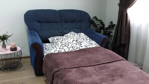A room with a bed, a grey rug, a blue blanket, and a patterned pillow. - apartments are located in a quiet area near the park. there are 2 restaurants (Lviv)