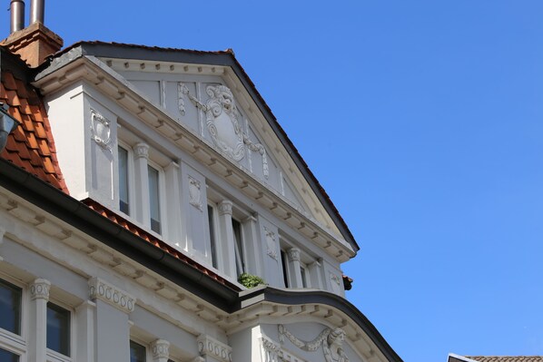 Un coin d’un bâtiment présentant des détails architecturaux élaborés, notamment des colonnes et des moulures décoratives.