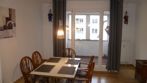 A dining area with a table and chairs, a view through a glass door, and a dresser. - Unique Maisonette Suite for 6 people, Refurbished Historical Villa! Nice Price!! (Bad Salzuflen)