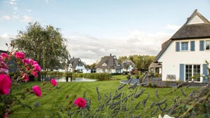 Un quartier résidentiel avec des maisons, un étang et une pelouse bien entretenue.