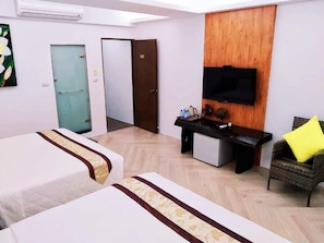 Une chambre d’hôtel avec deux lits, un bureau, une télévision et une chaise.