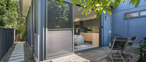 A modern house with a sliding glass door leading to a kitchen and dining area.