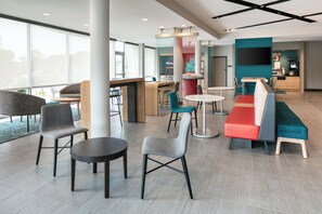 A modern lounge area with seating arrangements, a bar, and a kitchen area. - avid hotel Roseville - Minneapolis North by IHG (Roseville)