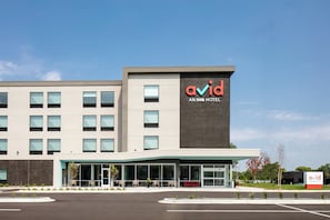 A modern building with a prominent 'avid' sign, indicating it is an IHG hotel. - avid hotel Roseville - Minneapolis North by IHG (Roseville)