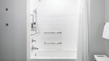 A modern bathroom with a bathtub, shower, and toilet.