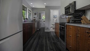 A modern kitchen with dark wood cabinets, a stainless steel microwave, and a built-in oven. - Spectacular Views, Single Level w/ Huge Deck & BBQ, Pet Friendly, Next to Forest Park Hiking Trails (Portland)