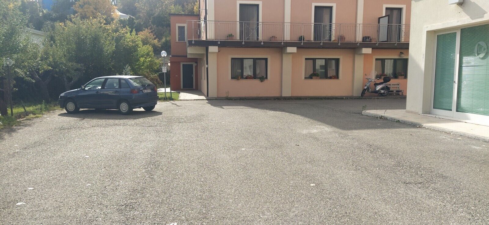 A residential building with a car parked in front.