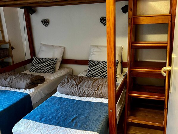 A room with two beds, a wooden ladder, and a shelf unit. - Renovated chalet for 6, Smart TV, WiFi, parking, pets allowed (La Joue du Loup)