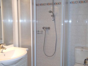 Ein Badezimmer mit Dusche, Toilette und Waschbecken.
