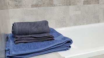 Bañera con ducha, secador de pelo, toallas, papel higiénico
