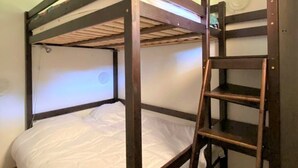 A bunk bed with a ladder, white bedding, and a plain wall with a circular window. - Renovated 4 ppl apartment with balcony, pets allowed (La Joue du Loup)