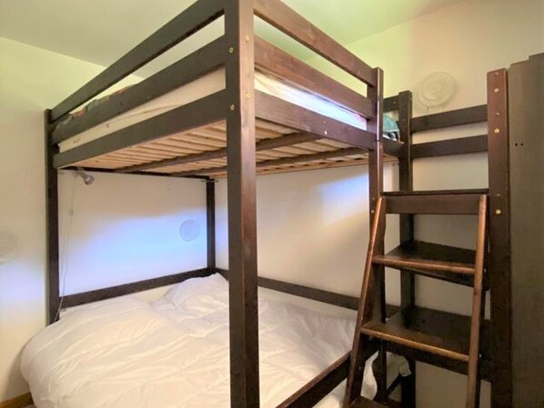 A bunk bed with a ladder, white bedding, and a plain wall with a circular window. - Renovated 4 ppl apartment with balcony, pets allowed (La Joue du Loup)