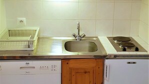 A kitchen with a stainless steel sink, a dish rack, a stove, and a dishwasher. - Renovated 4 ppl apartment with balcony, pets allowed (La Joue du Loup)