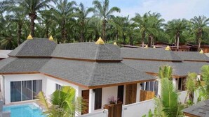 A resort with multiple villas, each with a private pool and surrounded by palm trees.