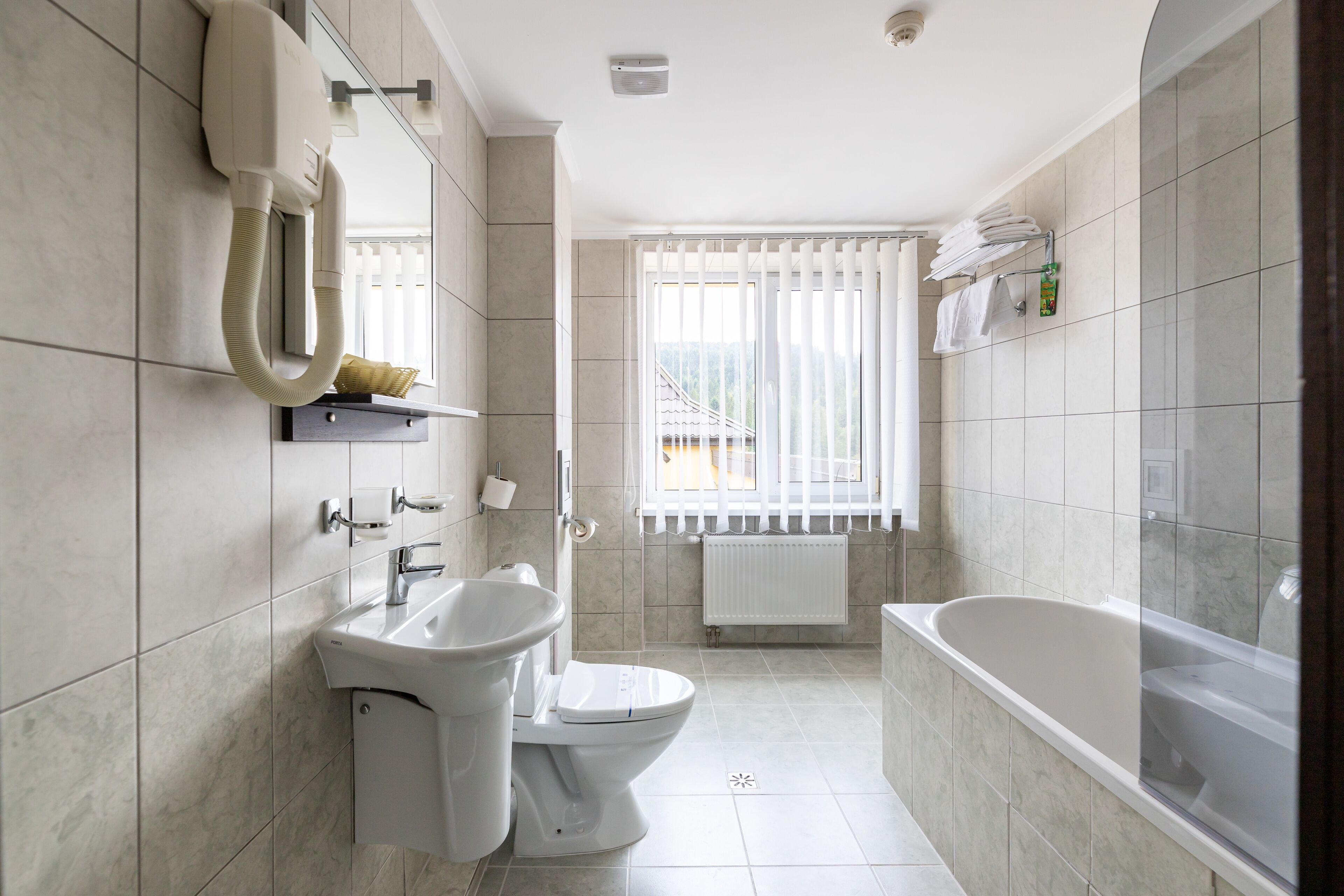 Un baño moderno con inodoro, lavamanos y bañera.