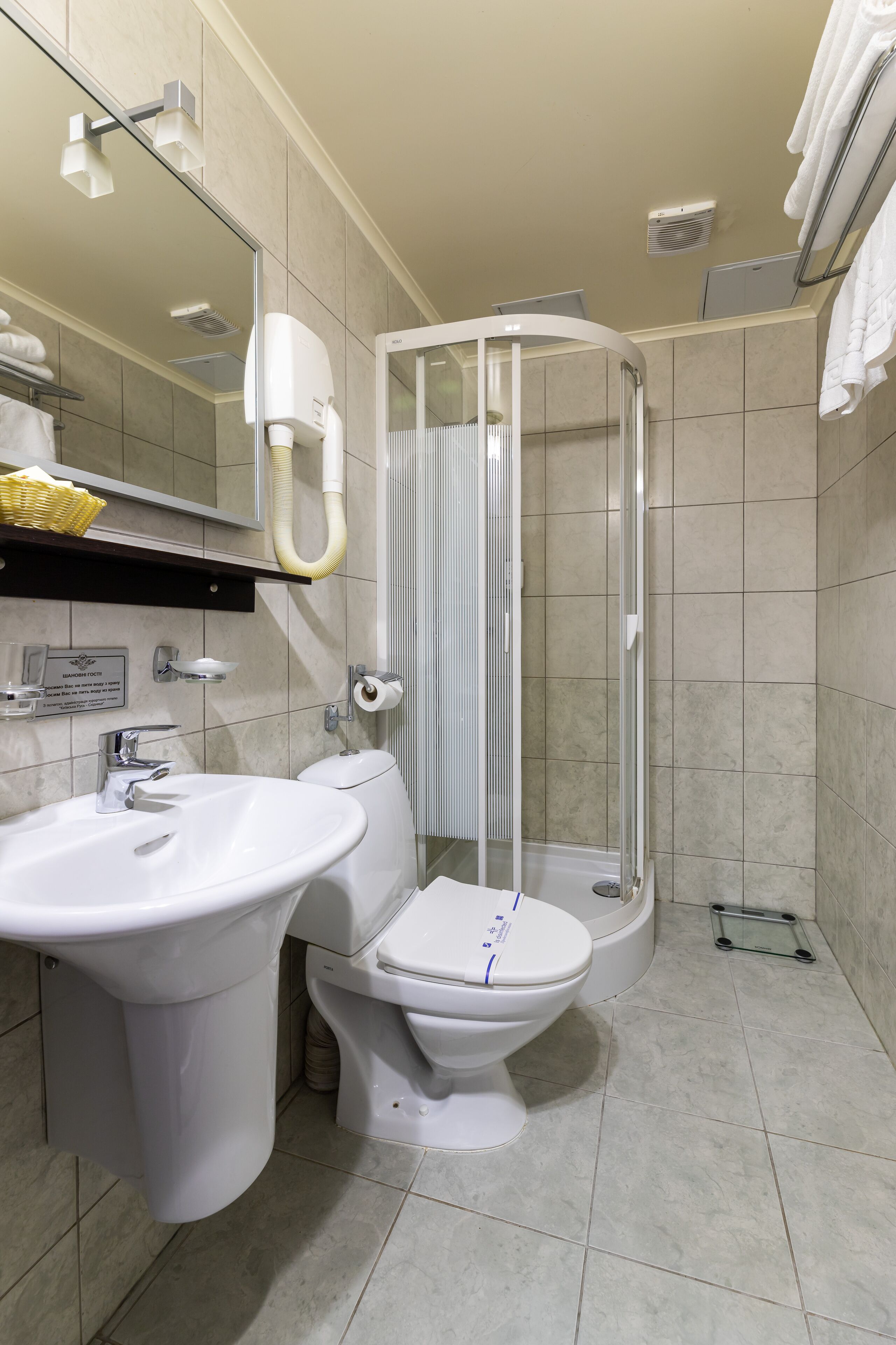Un baño moderno con lavamanos, inodoro y ducha con cerramiento de vidrio.