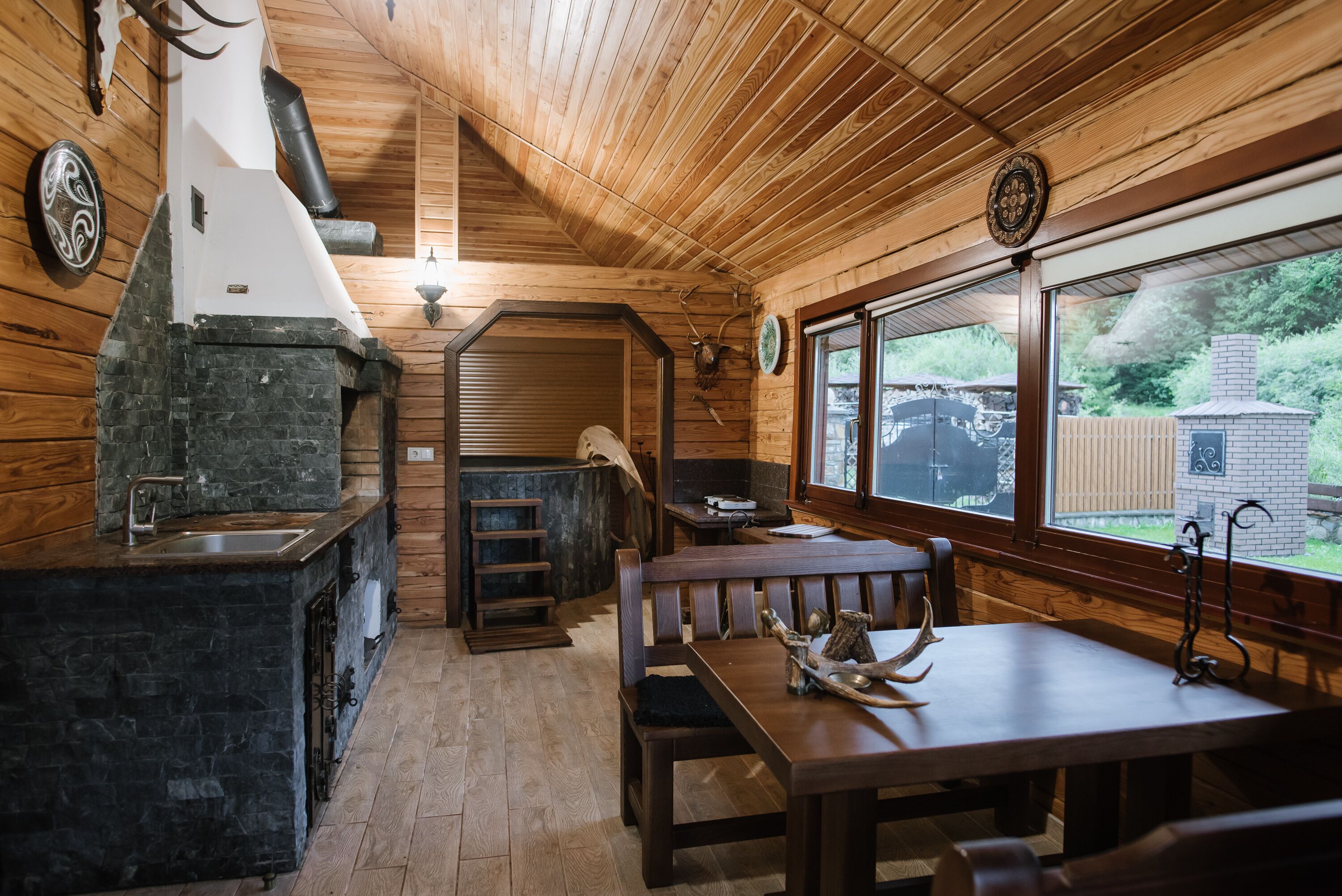 Un intérieur en bois avec un évier en pierre, un banc et une table à manger.